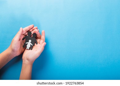 Life Insurance, Concept Of Love And Family . Close-up Of Hands Holding A Family On A Light Blue Background.