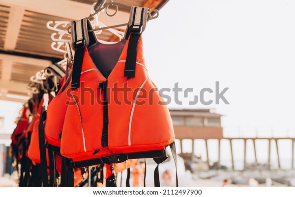 Life jacket on rail for costumer,\
Red Life jacket with black belts, Personal flotation device. Life\
jacket ready to be used by tourist going on a boat\
trip.