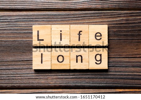 life long word written on wood block. life long text on table, concept.