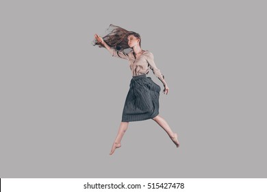 Life in motion. Studio shot of attractive young woman hovering in air