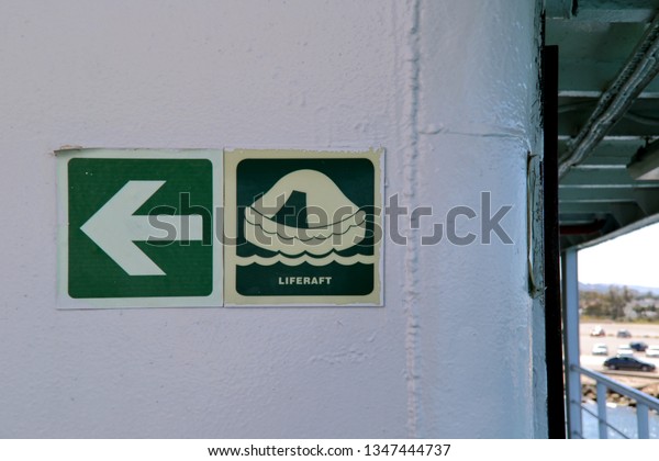 Life raft and arrow signs\
on a ship.