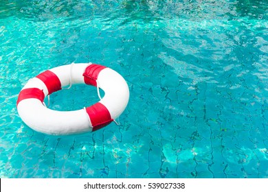 Life Ring On Blue Water At The Swimming Pool.