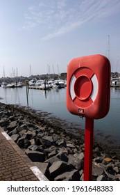 Life saving emergency floatation ring in a case on the side of a marina.