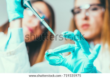 Life science research. Technicians using micro pipette