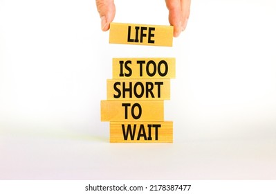 Life is short to wait symbol. Concept words Life is too short to wait on wooden blocks on a beautiful white table white background. Businessman hand. Business motivational life or wait concept.