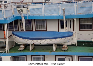 A Lifeboat Covered With A Blue Awning Stands On The Middle Deck Of A Modern Passenger Motor Ship

