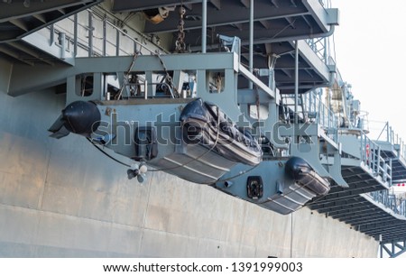 Lifeboat hanging on battle ship at port
