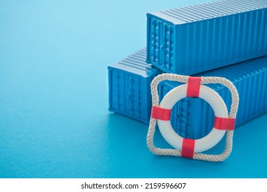 Lifebuoy with blue containers on blue background with copy space. Marine cargo shipment or freight insurance in global shipping and logistic industry. Insurance is risk management control.
