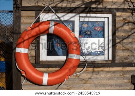 A lifebuoy hangs near the window at the boat station. The waves on Lake Almazne are reflected in the window. Kyiv. Ukraine.