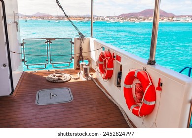 Lifebuoy on the deck of a luxury yacht in the sea. View from the deck of a yacht with lifebuoy and rope - Powered by Shutterstock