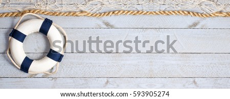 Lifebuoy on wooden background texture with rope and fishing net, copy space for individual text
