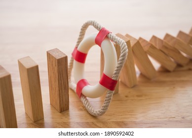 Lifebuoy Stop Wood Block Fall Domino Effect On Office Wooden Table Background. Life, Health And Property Insurance Business Concept. Insurance Is Risk Control Management.
