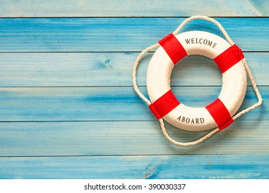 Lifebuoy with Welcome aboard phrase on wooden background