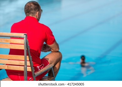 Lifeguard In Chair, Overlooking Swimming Pool