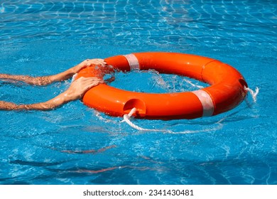 Lifeguard girl training with a life preserver swimming in the pool.