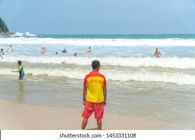 Lifeguard Man Standing And Looking With Rescue Can At The Beach