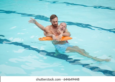 Lifeguard rescuing unconscious senior man from swimming pool - Powered by Shutterstock