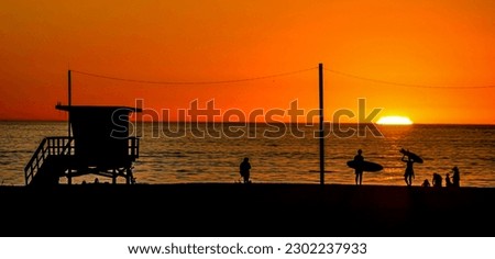 A lifeguard station and family surfing serve as a backdrop to this Santa Monica Beach California sunset