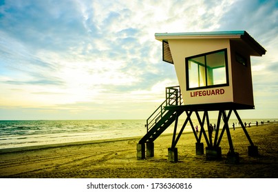 Lifeguard tower on the beach behind with crowd of tourist, scenic sea and cloudy sky in the evening. Seascapes with retro colors filter. Concept of tourism and vacation on paradise beach in summer. - Powered by Shutterstock