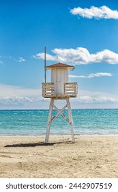 Lifeguard tower on the beach on a day with calm sea and blue sky with clouds