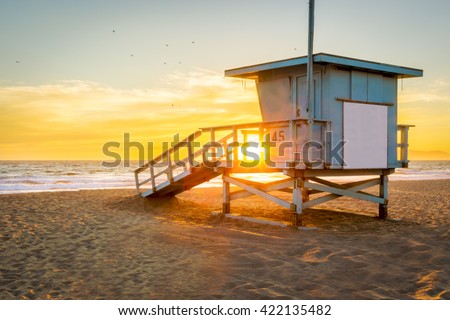 Lifeguard Tower on the Beach at Sunset with the Sun shining through.