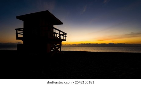 Lifeguard tower silhouette at sunshine, with purple sky and Atlantic Ocean in the background. World famous travel location. Miami beach, Florida.  - Powered by Shutterstock