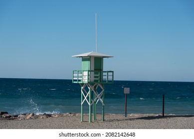 Lifeguard tower at Torrenueva Costa, Spain, empty beach on a sunny day in November. The text on the sign is Spanish for 'do not to swim next to the groins - do not jump from the groins'. - Powered by Shutterstock