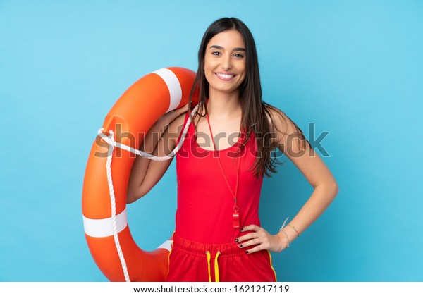 Lifeguard woman over isolated blue\
background with lifeguard equipment and with happy\
expression