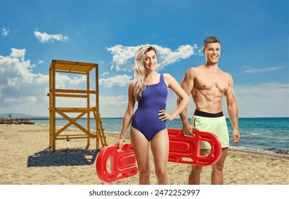 Lifeguards holding swimming floats at a beach with a lifeguard tower - Powered by Shutterstock