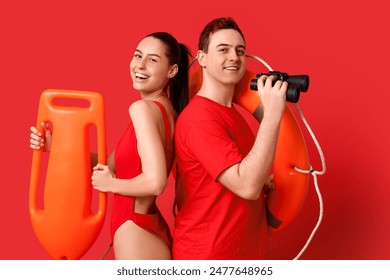 Lifeguards with ring buoy, rescue tube and binoculars on red background - Powered by Shutterstock