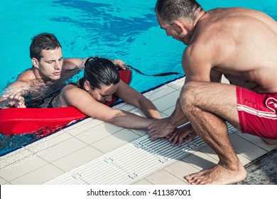 Lifeguards in training - Rescuing victim from public swimming pool - Powered by Shutterstock