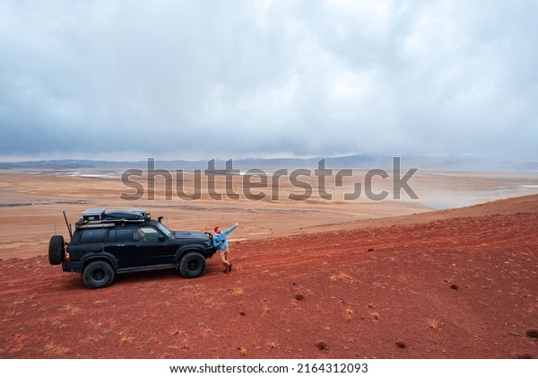 Lifeless landscape mountains Altai Republic Russia\
with expedition car, texture of red sand in Mars valley, aerial top\
view.