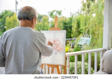 Lifestyle artist  Senior old man painting picture artwork using brush   water color canvas  portrait elderly white haired paint at his easel outside green nature  Happy retirement   activity