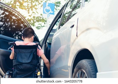 Lifestyle Of Asian Special Child On Wheelchair Going Up On A Car Parked In A Disabled Parking Space, Life In The Education Age Of Disability Children, Happy Special Need Kids Concept.