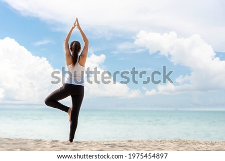 Lifestyle athletic woman yoga exercise and pose for healthy life.  Young girl or people pose balance body vital zen and meditation workout and fitness sport outdoor on sand beach