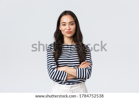 Lifestyle, beauty and fashion, people emotions concept. Skeptical and judgemental asian female office manager looking picky, smirk and pouting dissatisfied, cross arms chest