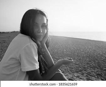 Lifestyle black and white portrait of beautiful smiling girl on the beach under sunlight