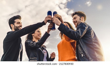 Lifestyle concept of young people raising hands with canned beers and having fun celebrating toasting together - Powered by Shutterstock