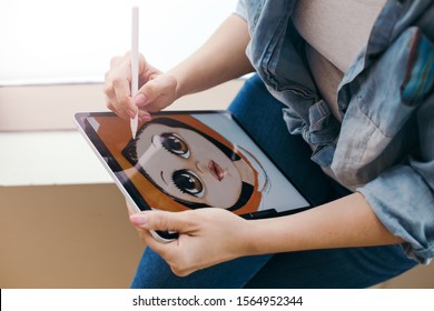 Lifestyle creative hobby and freelance artistic work job concept. Caucasian woman artist illustrator painting drawing on touch pad digital tablet with stylus. Process of creating illustration.