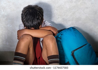 Lifestyle Dramatic Bullying Victim Portrait Of Young Sad Scared Kid 8 Years Old In School Uniform And Backpack Sitting Alone Crying Depressed And Frightened Suffering Abuse Problem Being Bullied