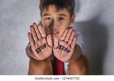 Lifestyle Dramatic Isolated Portrait Of Young Kid Sad And Depressed Suffering Bullying Problem And Abuse At School With Stop Word Written On His Hands Feeling Helpless In Bullied Child Victim