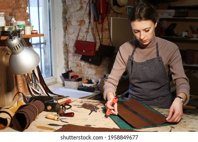 Lifestyle, Freelance And Home Business Concept: Young Woman Works In A Bag Making Studio, Cuts Out Details