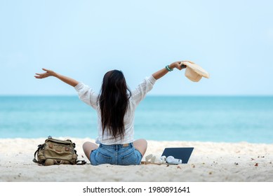 Lifestyle freelance woman raise arms relax after using laptop working on the beach.  Asian people success and together your work pastime and meeting conference on internet in holiday. Business holiday - Powered by Shutterstock