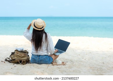 Lifestyle freelance woman  using laptop working and relax on the beach.  Asian people success and together your work pastime and meeting conference on internet in holiday. Business and Summer Concept