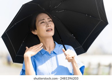 Lifestyle image of a young woman walking with a parasol - Powered by Shutterstock