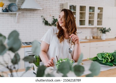 Lifestyle moments of a young woman at home. Woman preparing a salad in the kitchen