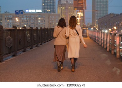 Lifestyle of Moscow citizens. Two great women walking in night Moscow. They cross the bridge in the city center. They wear modern stylish clothes, they are beautiful. Calmness. - Powered by Shutterstock