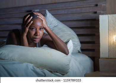 Lifestyle Night Portrait Of Young Scared And Stressed Black African American Woman On Bed Upset Unable To Sleep Suffering Hangover Headache And Insomnia Feeling Sick And Depressed