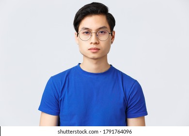 Lifestyle, People Emotions And Beauty Concept. Close-up Of Serious-looking Young Hipster Asian Guy In Glasses With Nice Fresh Haircut, Standing Grey Background With Determined, Confident Expression