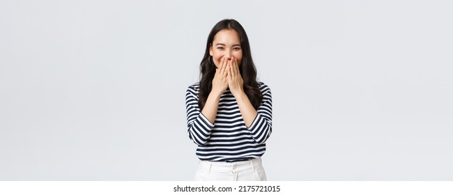 Lifestyle, People Emotions And Casual Concept. Cute Silly Asian Female Giggle While Gossiping And Mocking Someone, Cover Mouth As Smiling And Laughing Carefree